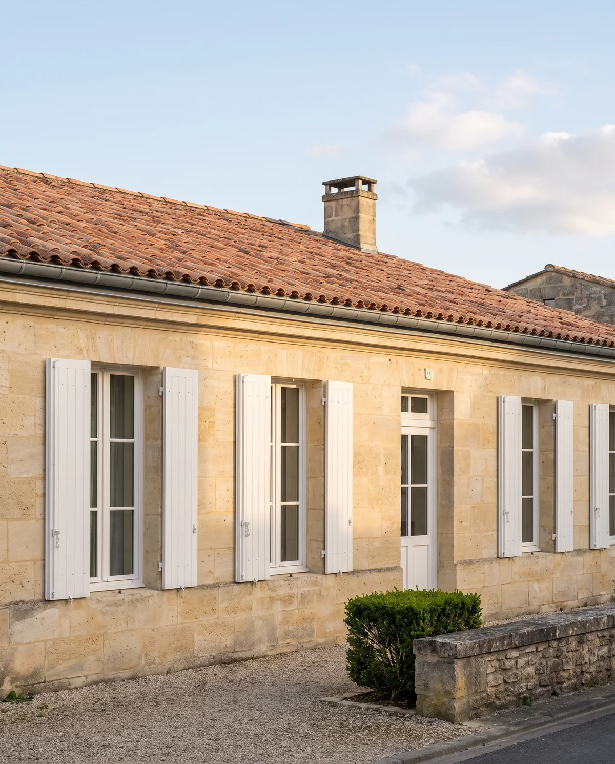 Maison en pierre de la métropole bordelaise, toiture en tuiles canal et volets repeints