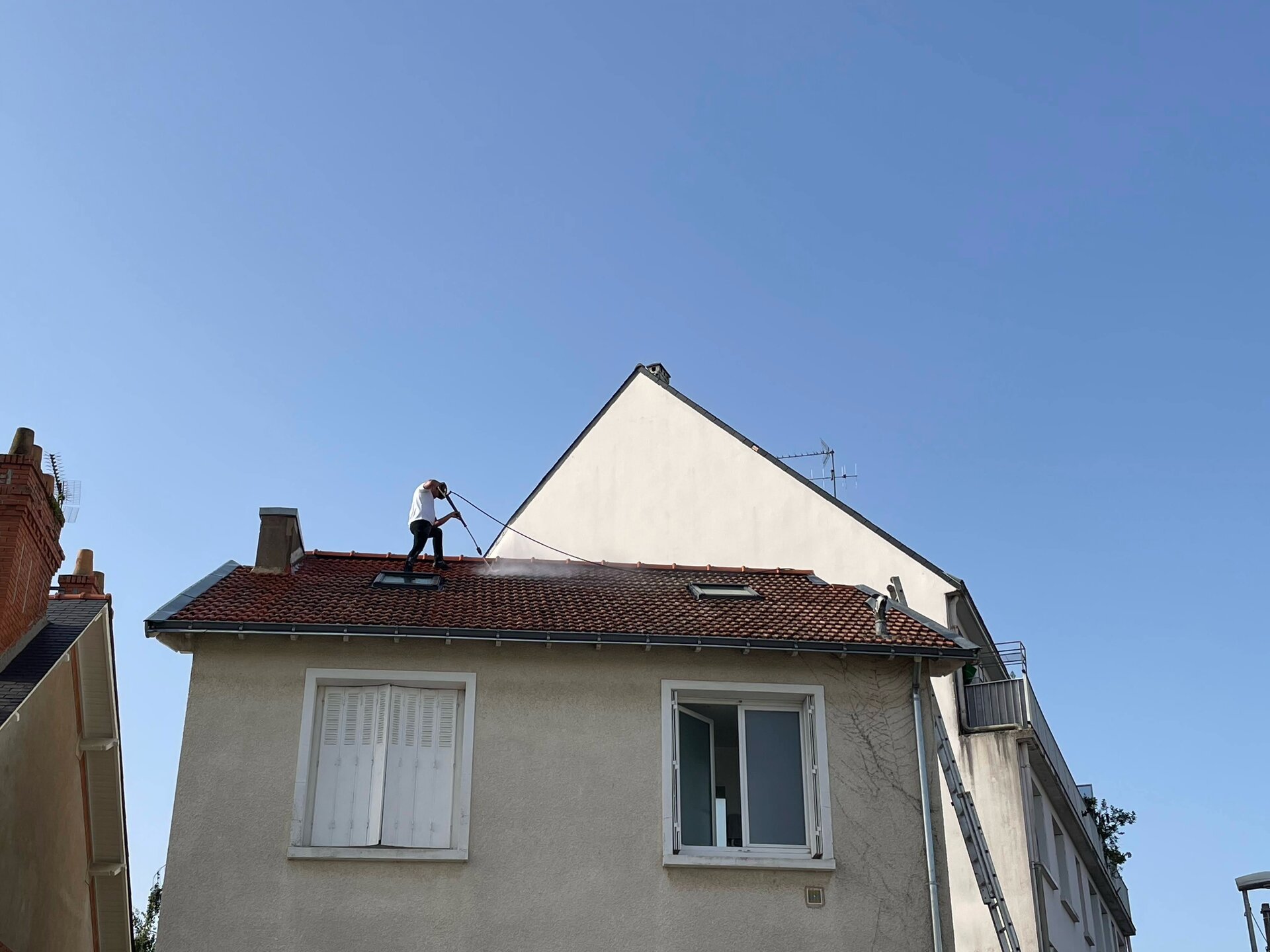 Nettoyage toiture haute pression - Artisan au travail