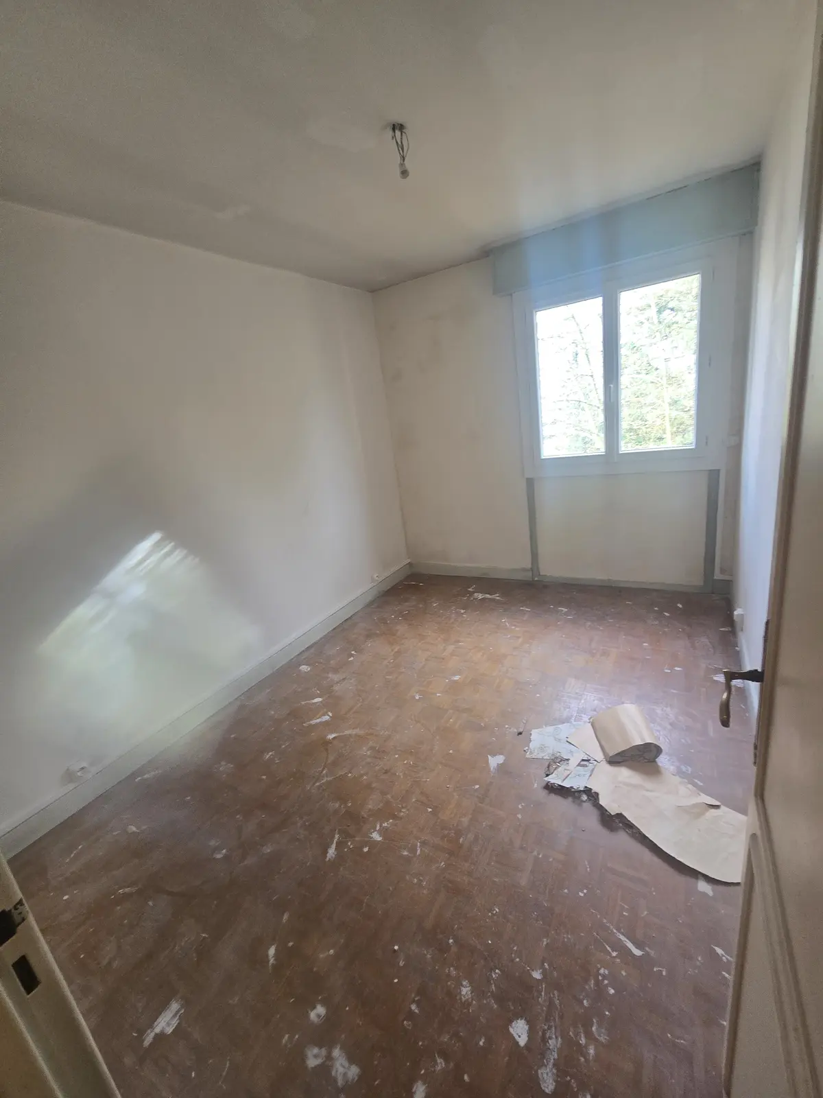 Chambre avant rénovation - Murs abîmés et sol usé